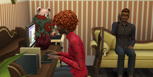 A Sim working at a computer while another Sim sits nearby in a romantic-themed room in The Sims 4.