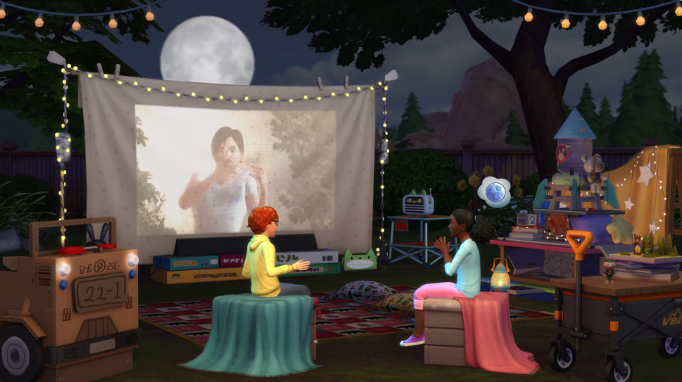 : Sims enjoying a backyard campout with tents, fairy lights, and a projector.